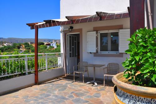 a patio with chairs and a table on a balcony at Lagos Studios & Apartments in Palekastron
