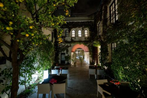 a building with a hallway filled with plants and tables at Hospes Palacio del Bailio, a Member of Design Hotels in Córdoba