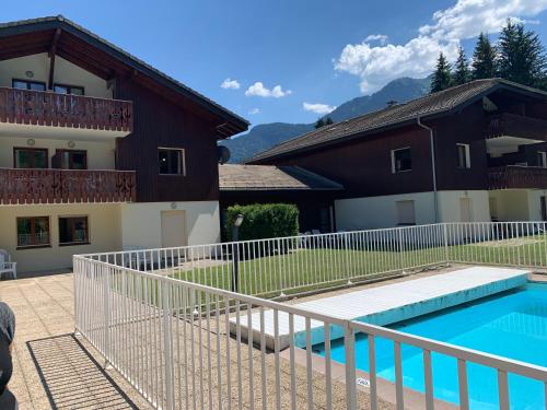 a villa with a swimming pool in front of a house at Le repère des écureuils in Samoëns