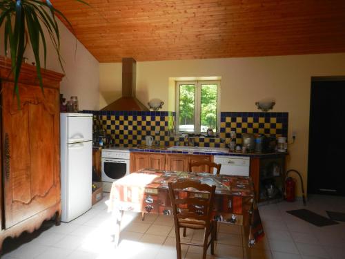 cocina con mesa y sillas en una habitación en Propriete d'une chambre avec jardin clos et wifi a La Mothe Saint Heray, en La Mothe-Saint-Héray