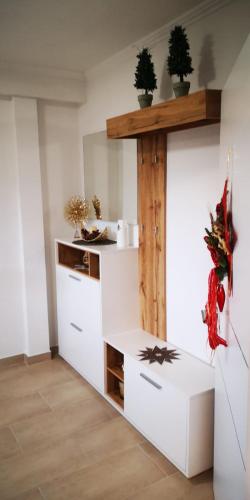 a kitchen with white cabinets and a wooden shelf at Haus am Fuße des Semmerings in Schottwien
