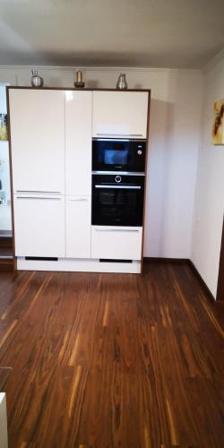 a kitchen with white cabinets and a black oven at Haus am Fuße des Semmerings in Schottwien