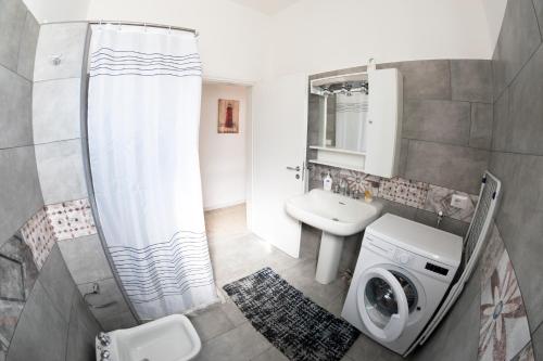 a bathroom with a sink and a washing machine at Casa tu Nonnu in Ugento