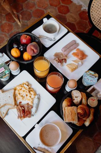 a table topped with plates of food and drinks at Les Manoirs des Portes de Deauville - Small Luxury Hotel Of The World in Deauville