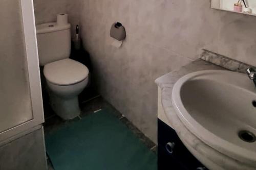 a bathroom with a white toilet and a sink at Piso Vintage Centro Gandía in Gandía