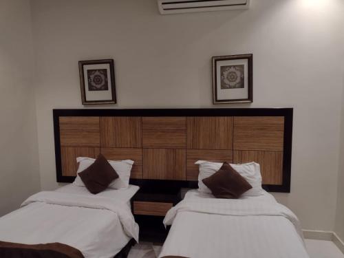 duas camas sentadas uma ao lado da outra num quarto em شقق النرجس فيلا للشقق المخدومة em Riyadh