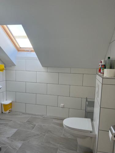 施韋夏特的住宿－Ruhige Grüne Oase bei Flughafen Schwechat，白色的浴室设有卫生间和天窗。