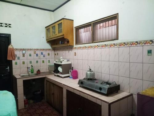 a kitchen with a counter with a microwave on it at HOMESTAY KARTINI SYARIAH in Bukittinggi