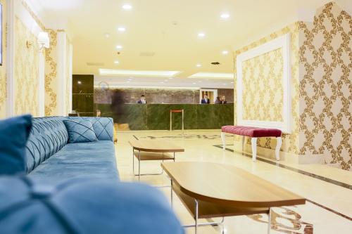 a living room with a blue couch and a table at Royal Hotel Inegol in Inegol
