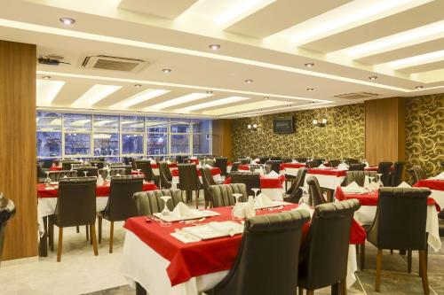 a restaurant with red and white tables and chairs at Royal Hotel Inegol in Inegol