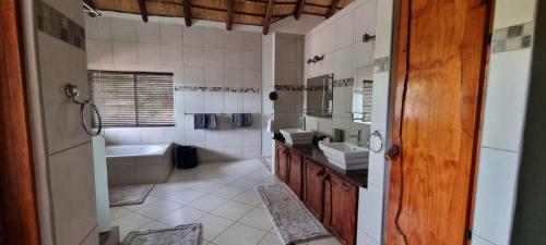 y baño con bañera, lavamanos y bañera. en Makhato Bush Lodge 48, en Bela-Bela