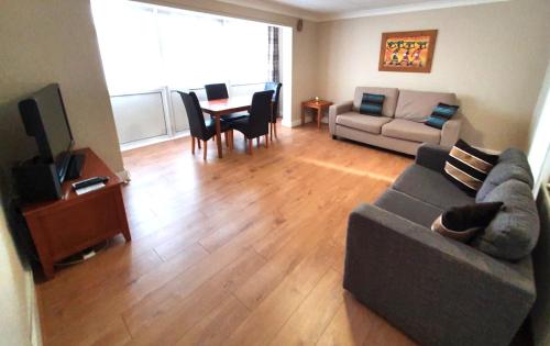 a living room with a couch and a table at Wentworth Apartment with 2 bedrooms, Superfast Wi-Fi and Parking in Sittingbourne