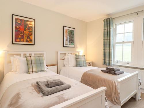 a bedroom with two beds and a window at Timley Knott in Coniston