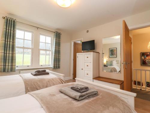 a bedroom with two beds and a mirror at Timley Knott in Coniston