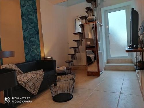a living room with a couch and a tv at Duplex avec jardin, proche village in Calenzana