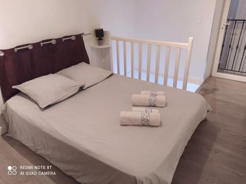 ein Schlafzimmer mit einem Bett mit zwei Handtüchern darauf in der Unterkunft Duplex avec jardin, proche village in Calenzana