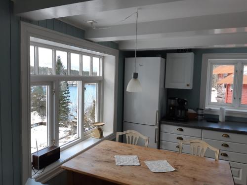 EikefjordにあるHoltarheim, holidayhouse, boat includedのキッチン(木製テーブル付)、窓2つが備わります。