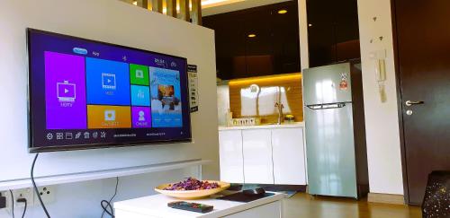 a television on a wall with a bowl of food on a table at Eshue Designer Suites @ Simfoni Towers in Cheras