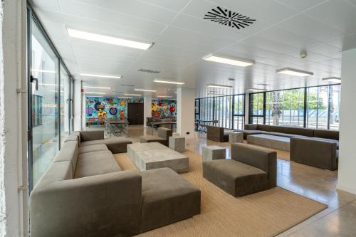 a waiting area with couches and chairs in a building at Micampus Alicante Student Residence in San Vicente del Raspeig