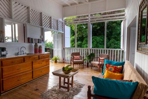 a living room with a couch and some windows at Castara Cottage by Hello Mello in Castara