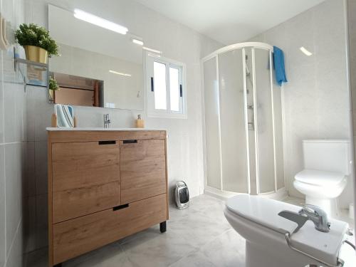 uma casa de banho com um lavatório, um WC e um espelho. em Casa do Cucharro en Playa de Soesto, Laxe em Laxe