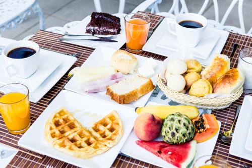 a table filled with breakfast foods and drinks at Pousada Sossego da Pampulha in Belo Horizonte