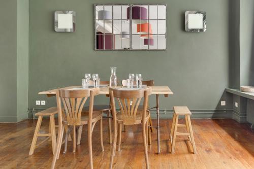 - une table à manger avec des chaises et un miroir dans l'établissement Appartement Gambetta - Atypique - Rue Calme - Quartier dynamique, à Paris