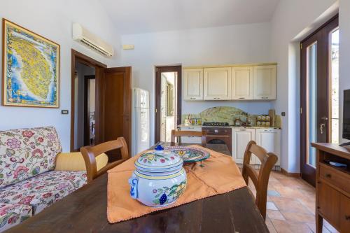 a kitchen and living room with a table with a pot on it at Casa Ulmi con piscina in Uggiano la Chiesa