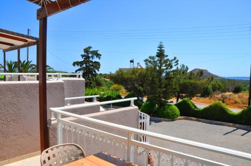 a balcony with a table and chairs and bushes at Lagos Studios & Apartments in Palekastron