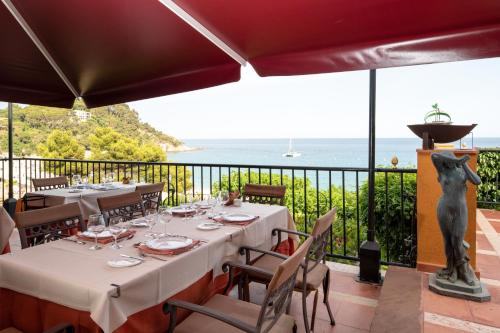 un restaurante con mesas y vistas al océano en Rigat Park & Spa Hotel - Adults Recommended, en Lloret de Mar