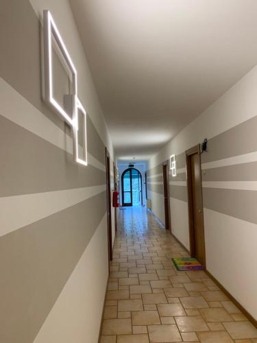 a hallway with a tile floor and striped walls at Hotel Lory Ficarolo in Ficarolo