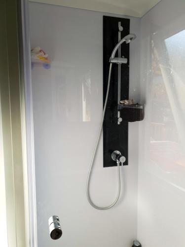 La salle de bains est pourvue d'une douche et d'un support noir. dans l'établissement Bungalow charmant à Saint-Cyprien + Piscine partagée, à Saint-Cyprien