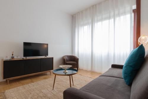a living room with a couch and a tv at Milan Retreats in Milan