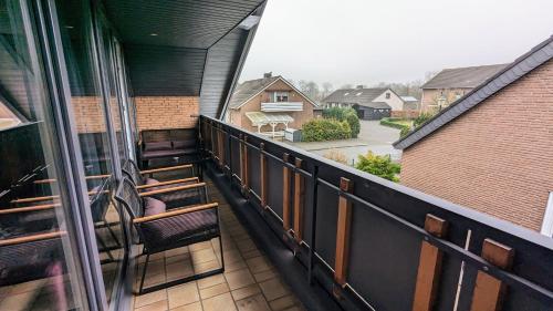 a balcony with chairs and a view of a street at Moderne Ferienwohnung mit Südbalkon in der Nähe der Stever in Lüdinghausen