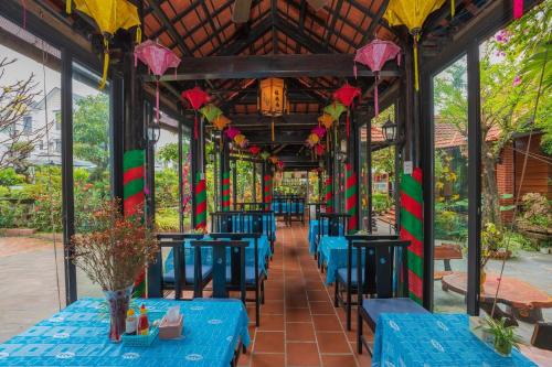 un restaurant avec des tables bleues et des décorations colorées dans l'établissement Betel Garden Villa, à Hội An