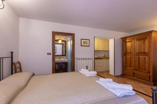 a bedroom with a large bed and a kitchen at Casa Ulmi con piscina in Uggiano la Chiesa