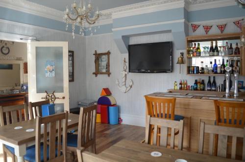 una sala da pranzo con tavolo e bar di The Rookery a Swanage