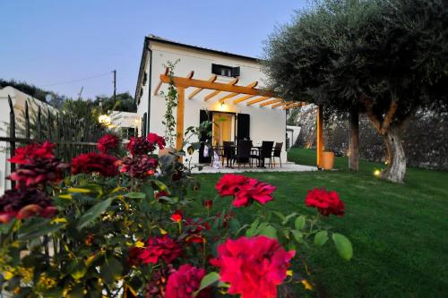 a house with a garden with red flowers in the yard at Myronis Villa Corfu Town in Corfu Town