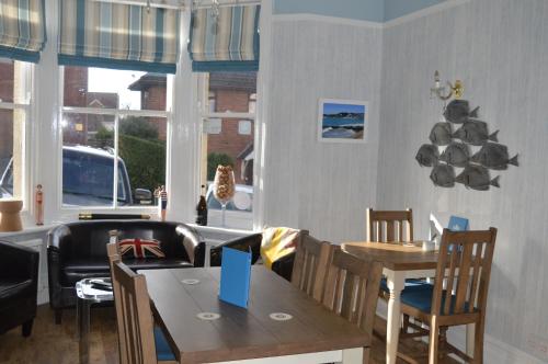 comedor con mesa, sillas y ventanas en The Rookery, en Swanage
