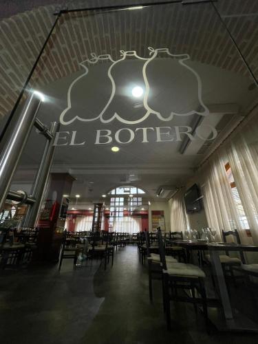 un comedor con mesas y sillas en un restaurante en Hostal El Botero, en Monreal del Campo