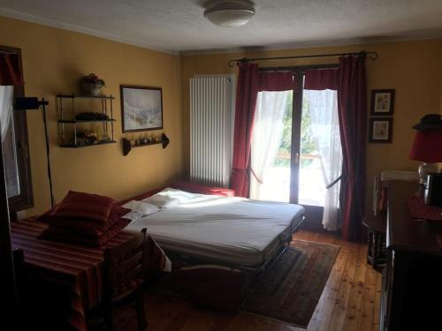 1 dormitorio con cama y ventana en Cozy mountains apartments en Borgata Sestriere
