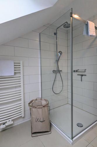 a shower with a glass door in a bathroom at Moderne Ferienwohnung mit Südbalkon in der Nähe der Stever in Lüdinghausen