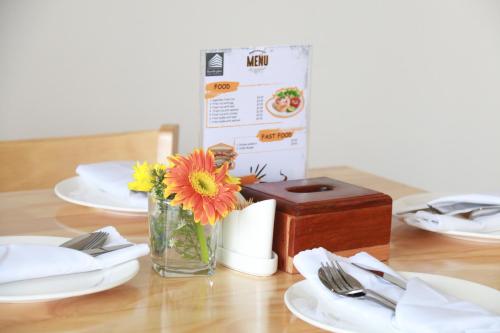 a table with plates and a vase of flowers and a box at White Corner Hotel in Phnom Penh