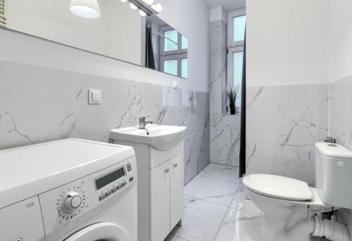 een witte badkamer met een wastafel en een toilet bij MonteFerber Modern Stylish Apartment in Center of Sopot in Sopot