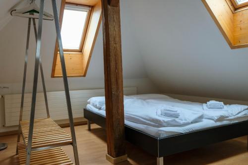 Habitación pequeña con cama y escalera en Spatzennest, en Spiez
