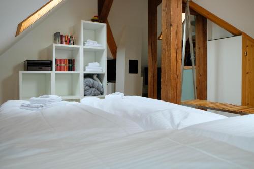 Una cama blanca con estanterías blancas en una habitación en Spatzennest, en Spiez