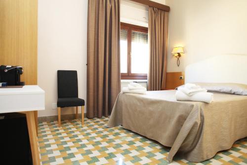 a hotel room with a bed and a chair at Albergo Russo in Trapani