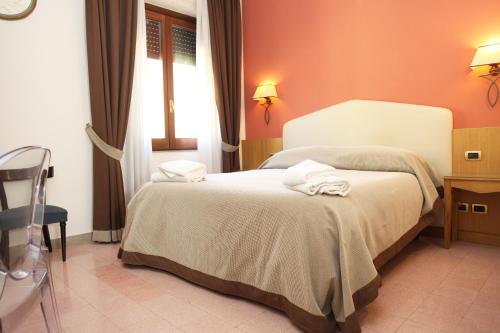 a bedroom with a large bed with orange walls at Albergo Russo in Trapani