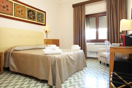 a hotel room with a bed with towels on it at Albergo Russo in Trapani