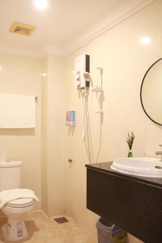 a bathroom with a toilet and a sink and a mirror at White Corner Hotel in Phnom Penh